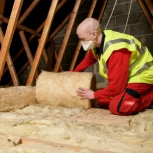 The Great British Insulation scheme in Swansea 3 man laying loft insulation in Wales30